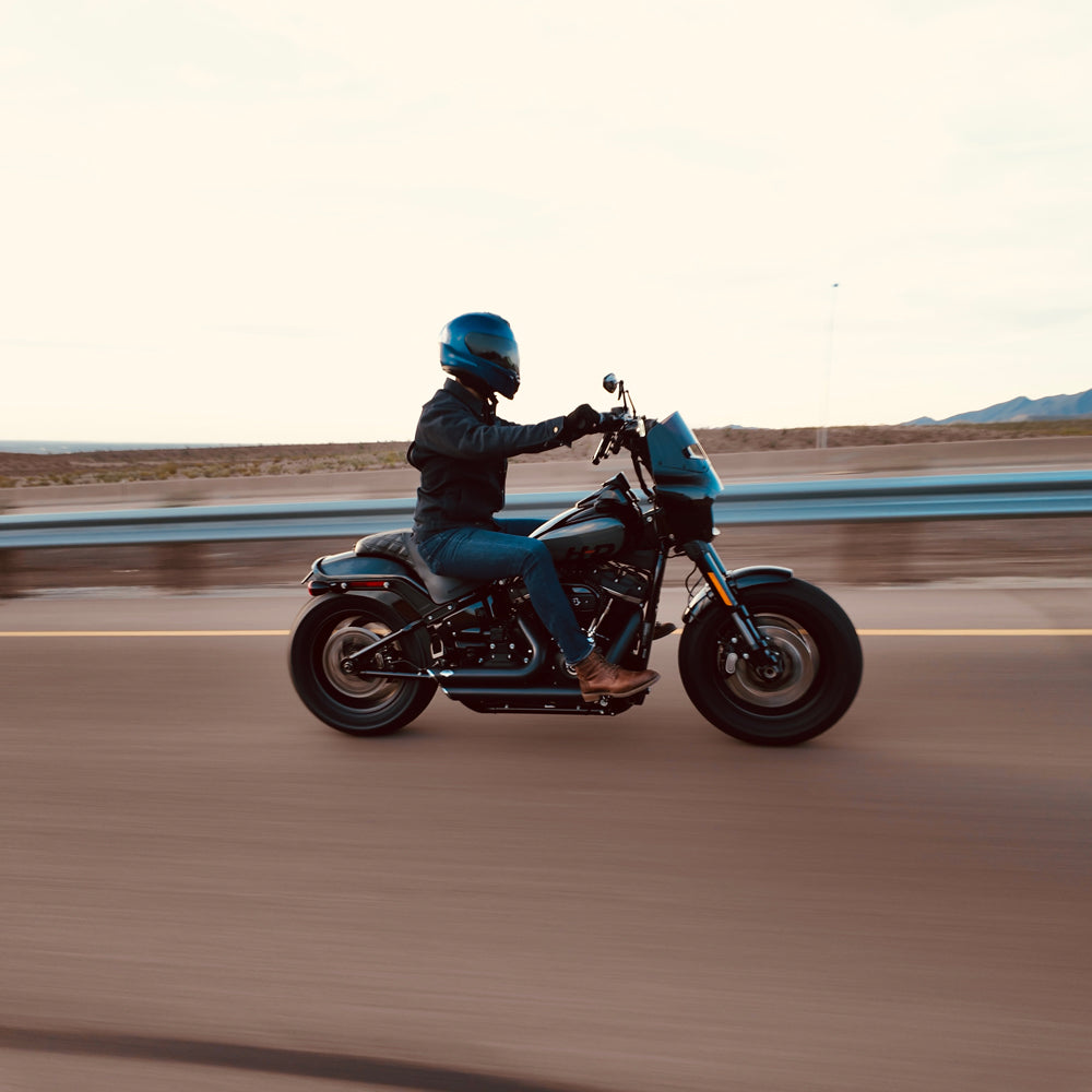 Person riding a motorcycle on a road with a blurred background